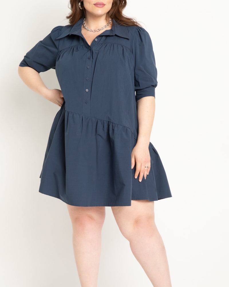 Front of a model wearing a size 16 Mini Dress With Asym Flounce in Dress Blues by ELOQUII. | dia_product_style_image_id:303861